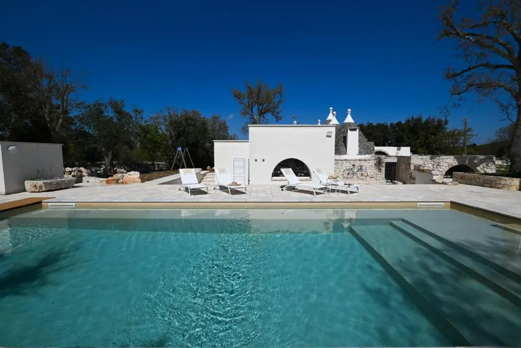 Piscina privata ad uso esclusivo con solarium immersa negli ulivi di Cisternino